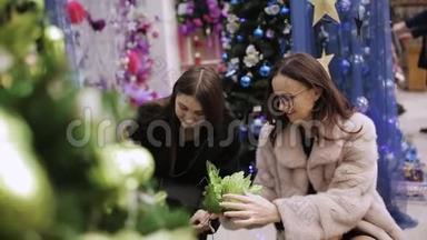 两个女人为圣诞商店的圣诞装<strong>饰品</strong>选择风景。 两位女士选择圣诞装<strong>饰品</strong>
